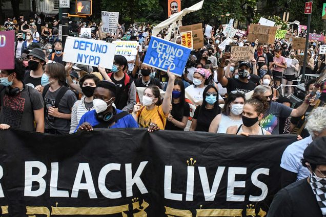 Photo of Defund Police Protestors Camp Outside NYC City Hall NEW YORK, NY on June 25, 2020. A multi-racial group of protestors hold various signs calling for the NYPD to be defunded. A group holds a large BLACK LIVES MATTER BANNER in the bottom of the frame.