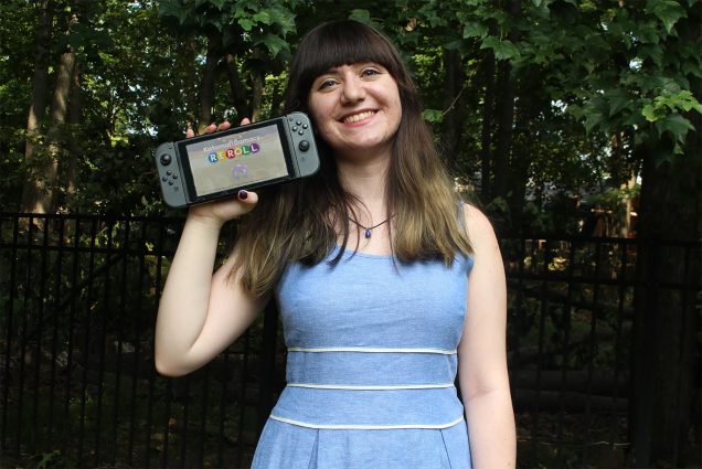 Photo of Sabrina Scotti (CFA’20) in a light blue dress holding Katamari Damacy REROLL, one of the children’s video games she studied as part of her an Undergraduate Research Opportunity Program–funded research into whether games use diverse music styles to further music education. She smiles and bushes are seen in the background.