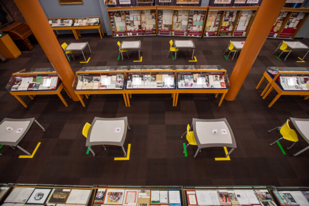 A photo of the first floor of Mugar Library showing socially distanced tables
