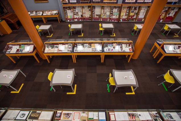 A photo of the first floor of Mugar Library showing socially distanced tables