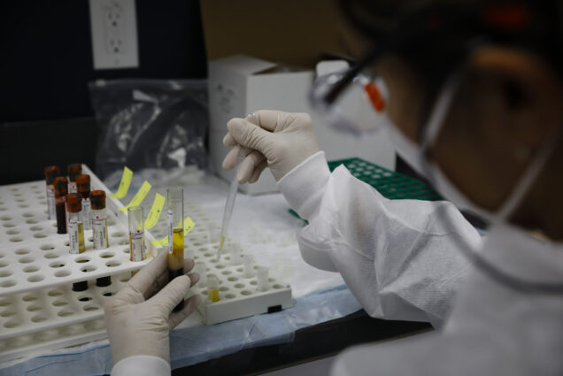 A photo of a researcher working on a vaccine in a lab