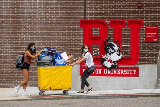 Roommates Jennie Young (CAS'24) (left) and Charlotte Bausha (CAS'24) work together to get Young's things into their Sleeper Hall dorm before the rain hit on August 27, while a stern, but unmasked, Rhett looks on in sculpture form behind them. Young and Bausha push a bright yellow cart filled with Young's belongings.