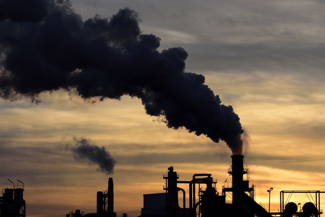 A photo of smokestacks spouting smoke into the atmosphere