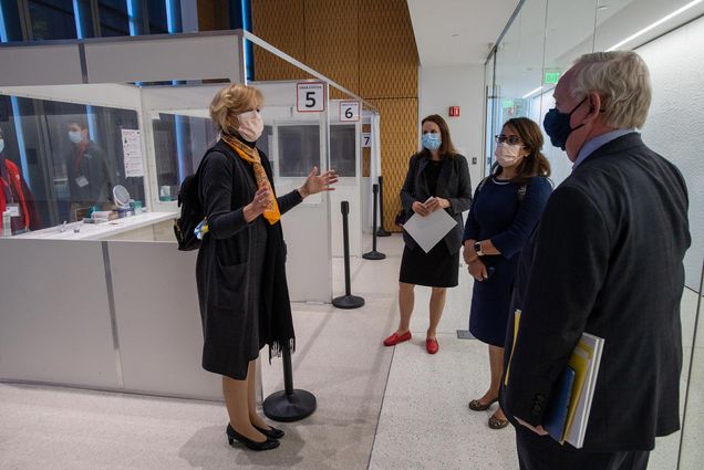 Photo of Deborah Birx, MD, Coronavirus Response Coordinator at the White House, wearing a mask and talking to BU staff during a tour of the testing site at Kilachand CILSE October 9, 2020. Also seen, from left, Dr. Catherine Klapperich Professor and Vice Chair of Biomedical Engineering, BU , Dr. Irum Zaidi, Chief Epidemiologist for Corona Response Coordinator, and President Robert A. Brown stop briefly to talk. The site was not in use while the group gathered, and the group stands at an appropriate social distance from one another.