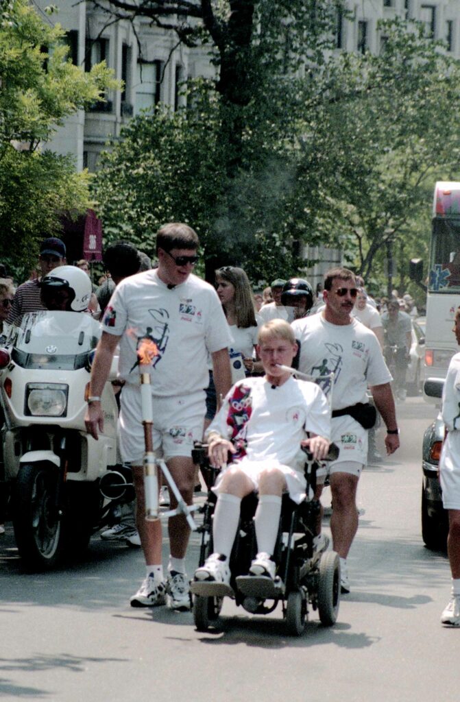 Travis Roy carries the Olympic Torch in 1996