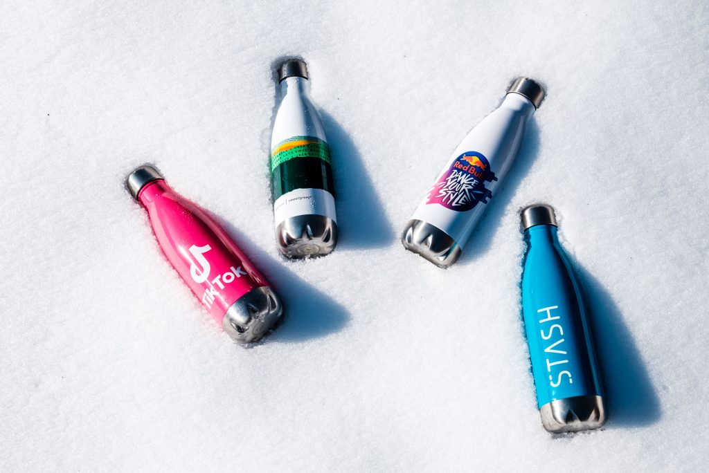 A photo of water bottles with various logos printed on them