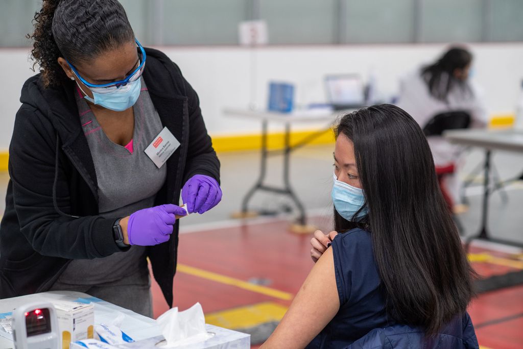 Student Health Services medical assistant Monica Barros gives Kyra Gordon (SAR’21,SPH’22) administrative coordinator at the BU Physical Therapy Center the Moderna COVID-19 vaccine January 20 at the vaccine clinic at FitRec.