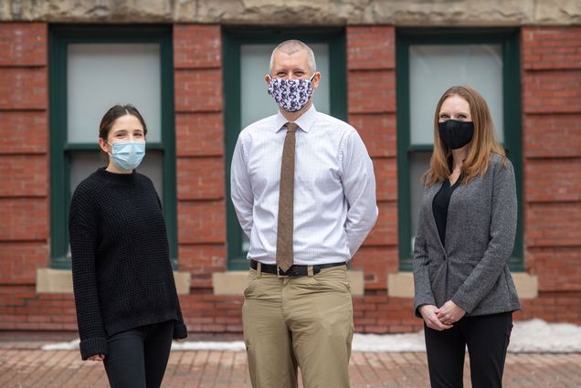 A photo of Sarah Gordon, Paul Shafer, and Megan Cole Brahim standing next to one another wearing masks