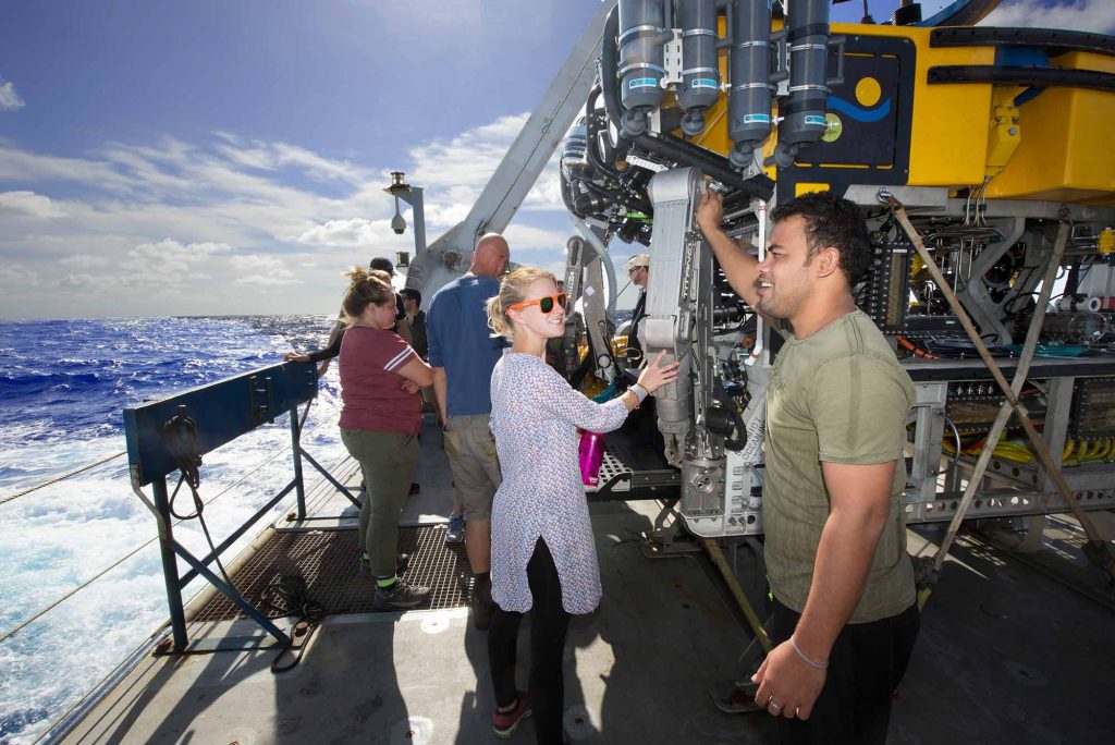Anna Gauthier and Aranteiti Tekiau talk next to the deep sea submersible ROV SuBastian on the deck of the R/V Falkor sailing in the Phoenix Islands Protected Area.