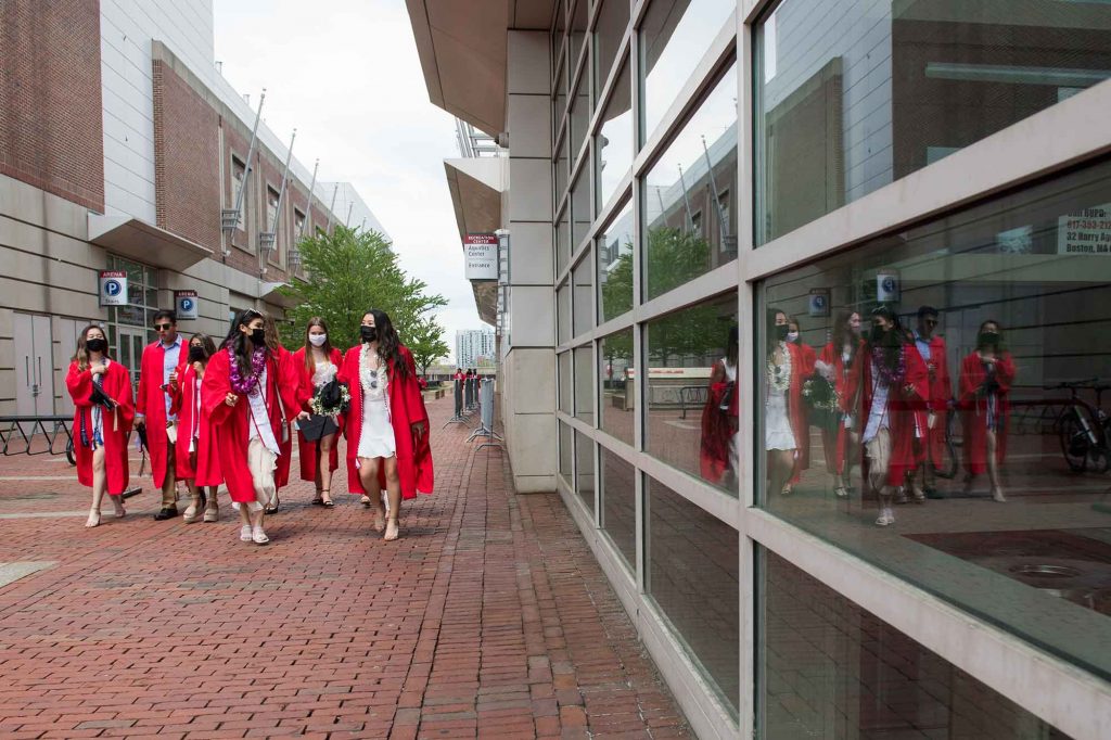A group of graduates walk towards Commonwealth Ave following Commencement.