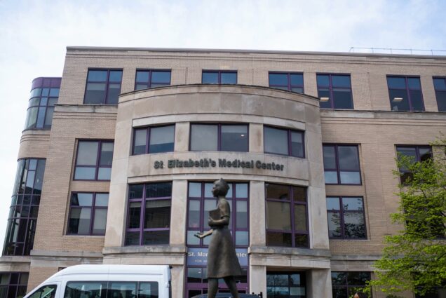 Photo of St. Elizabeth’s Medical Center in Brighton, MA. At center, a statue of a woman in bronze is seen.