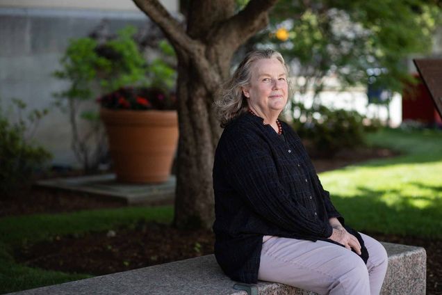 Virginia Sapiro sitting under a tree outside the Boston Universiy College of Arts and Sciences building.