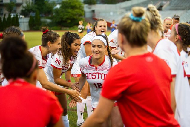 Photo of the women's soccer team giving each other high fives before the start of their game versus UMass lowell.