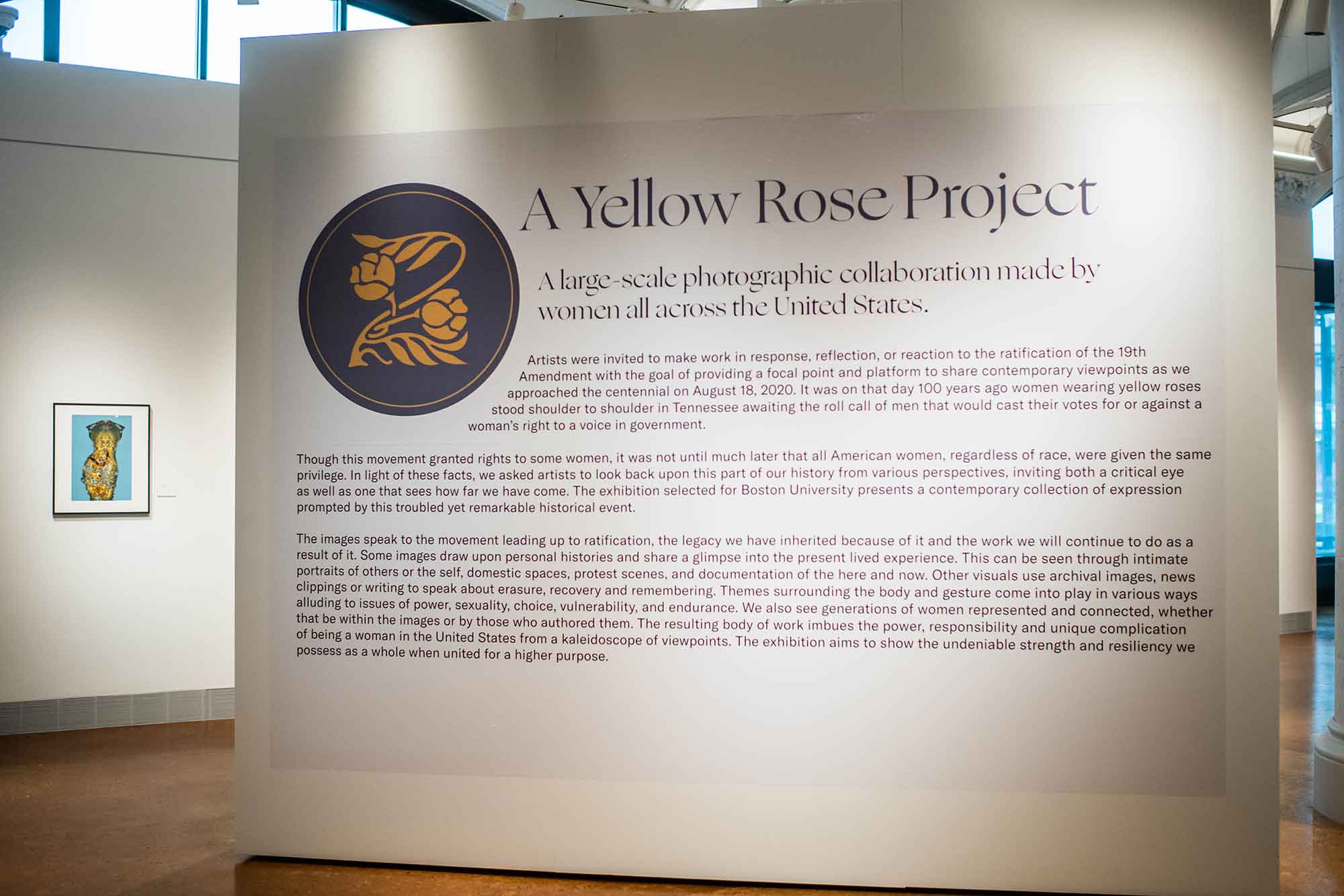Entrance to A Yellow Rose Project exhibit at Boston University's Stone Gallery where a wall displays the curatorial statement for the exhibit.