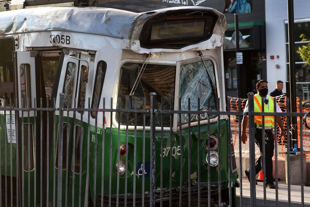 Photo taken July 30 of the scene of a crash between two Green line T trains near 971 Commonwealth Ave in Boston. The front of the green line car is smushed in, the glass is broken and the car lights are off.