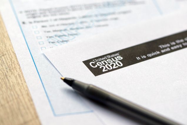 Photo of a piece of paper that says “Census 2020” in a header at the top. Another paper with blue boxes is underneath and a black pen rests on top.