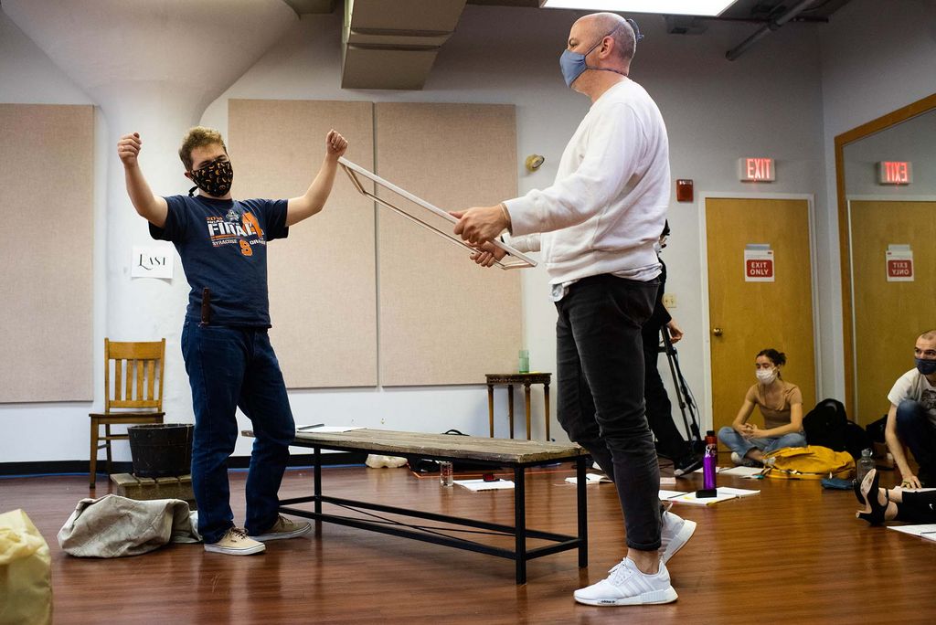 Jacob O’Shea (CFA’21,’23) (left) and stage director Nathan Troup (CFA’04) during a rehearsal of Proving Up. Troup stands with a window pane in his hands.