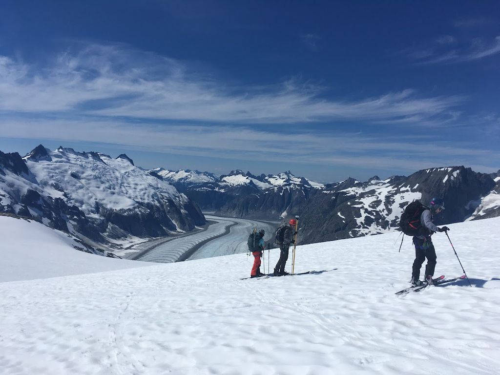 photo of three skiers, Randall in the lowest position on the slope, as her research group measures the position of stakes they placed on the Little Vaughan Lewis Glacier next to Camp 18.