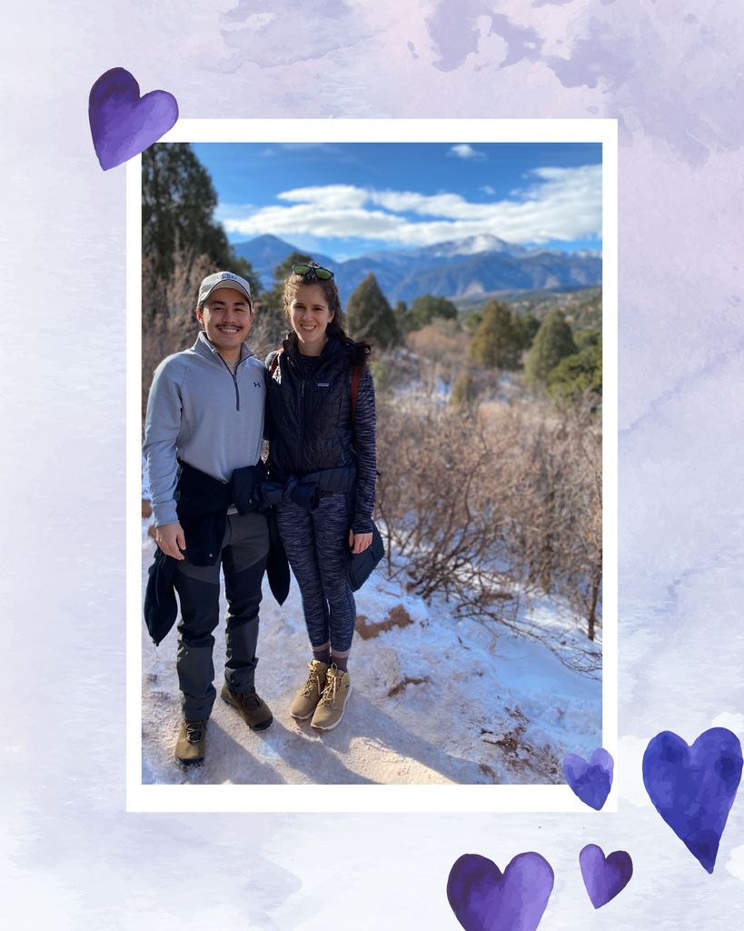 Photo of Whitney Souery and her partner during a hike with snowcapped mountains in the background. The photo has a white border and is overlaid on a purple watercolor background; purple watercolor hearts are also overlaid.