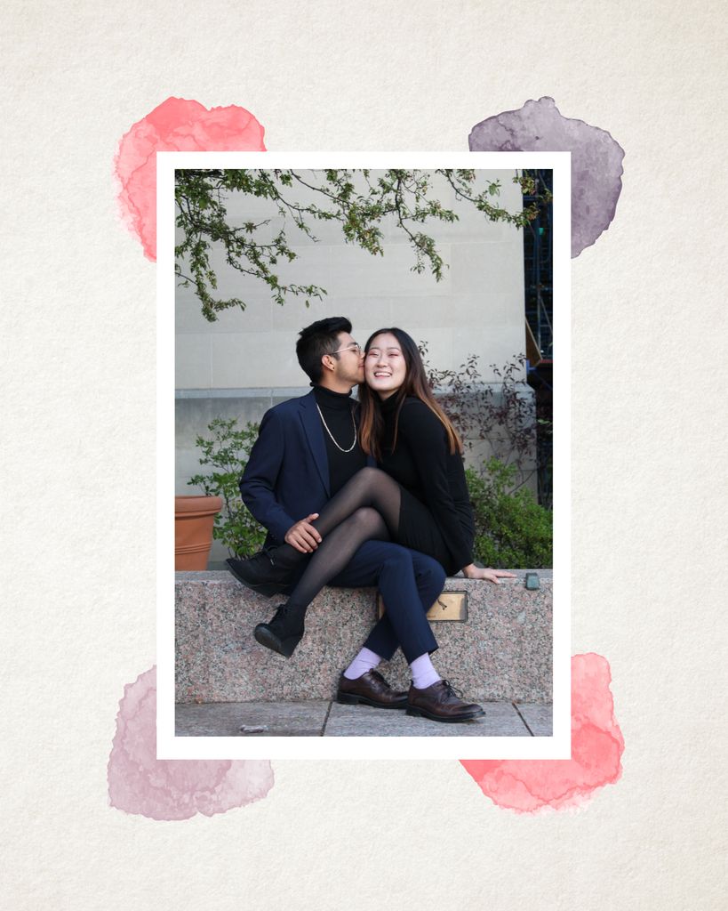 Photo of Elaine Park sitting with her legs over her partners outside on a bench as they kiss her cheek. The photo has a white border and each corner is framed by a pink or purple watercolor blob.