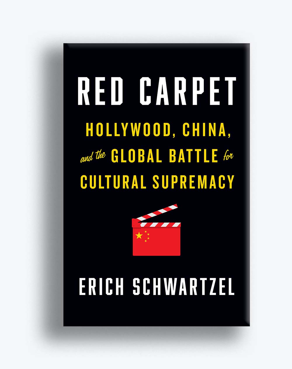Book cover for Erich Schwartzel's Red Carpet: Hollywood, China, and the Global Battle for Cultural Supremacy. The cover is black with white and yellow text, and features a red clapper board icon at the center. 