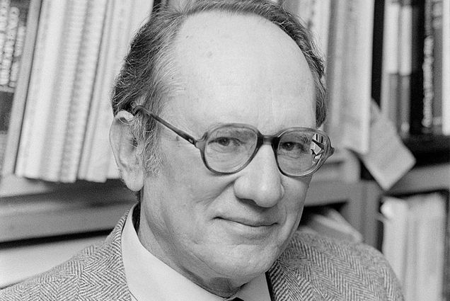 a portrait of Seymour Miller in black and white wearing glasses and a suit and tie