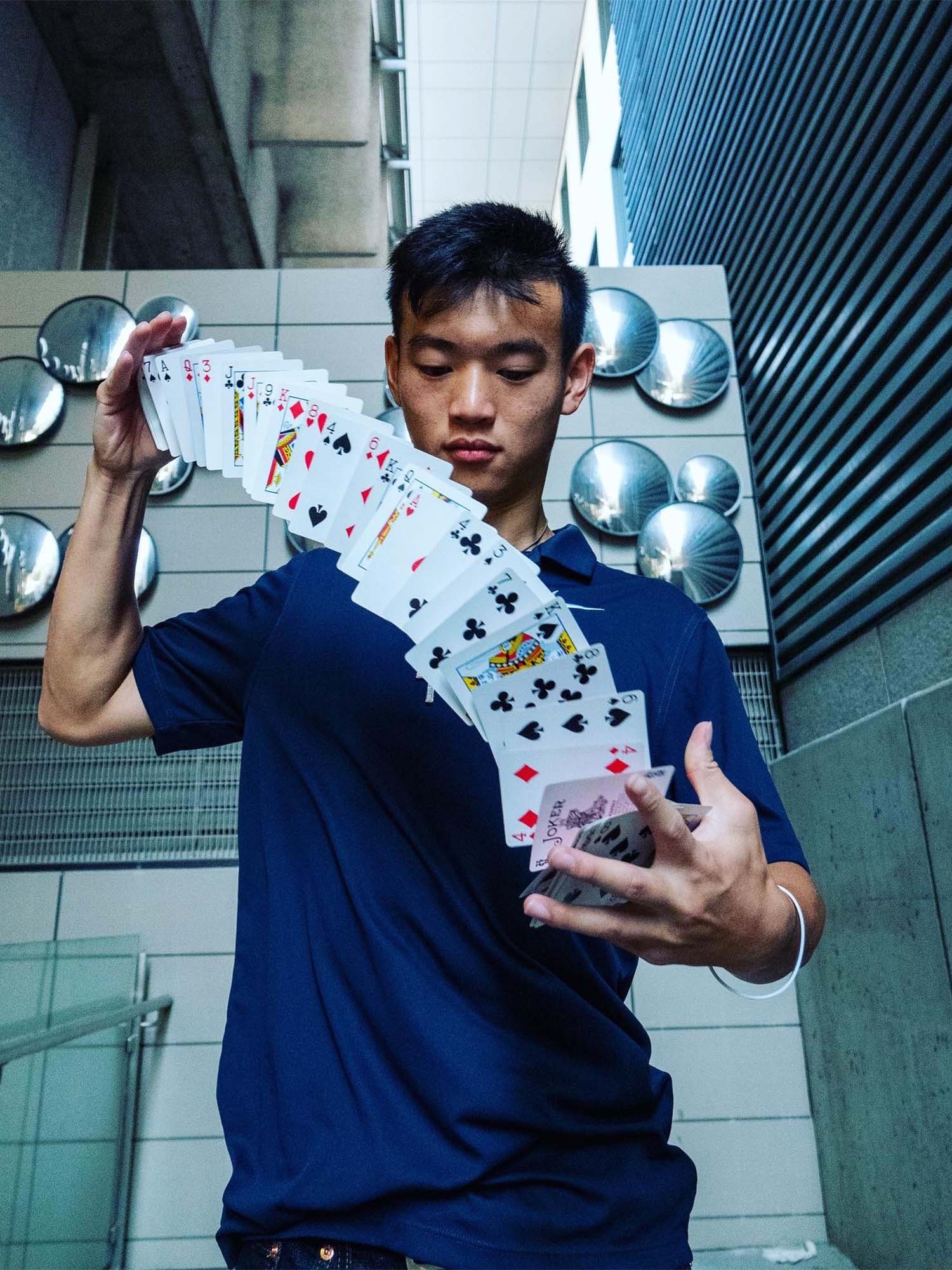 BU student Henry Di—who goes by the stage name Enrique the Magician—performs magic tricks on TikTok. Here he performs a card trick for the camera