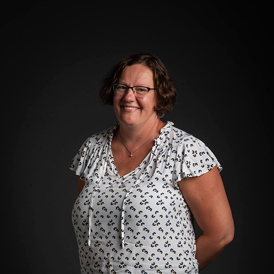 photo of CAS professor, Lucy Hutyra, as she poses with hands behind her back and wearing a white blouse in front of a black backdrop