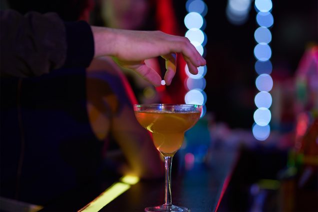 Picture is of a person dropping a pill into a drink at a bar. Boston police have recorded 71 allegations of drugged drinks so far this year, and BU Police Department officers say there’s been a noticeable increase throughout the city in the last year and a half. Photo courtesy of Peopleimages/iStock