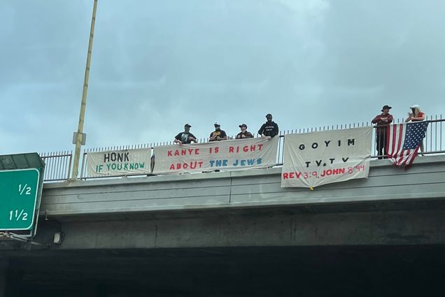 White supremacist nazis hang a sign over the 405 freeway reading "Kanye is right about the jews"