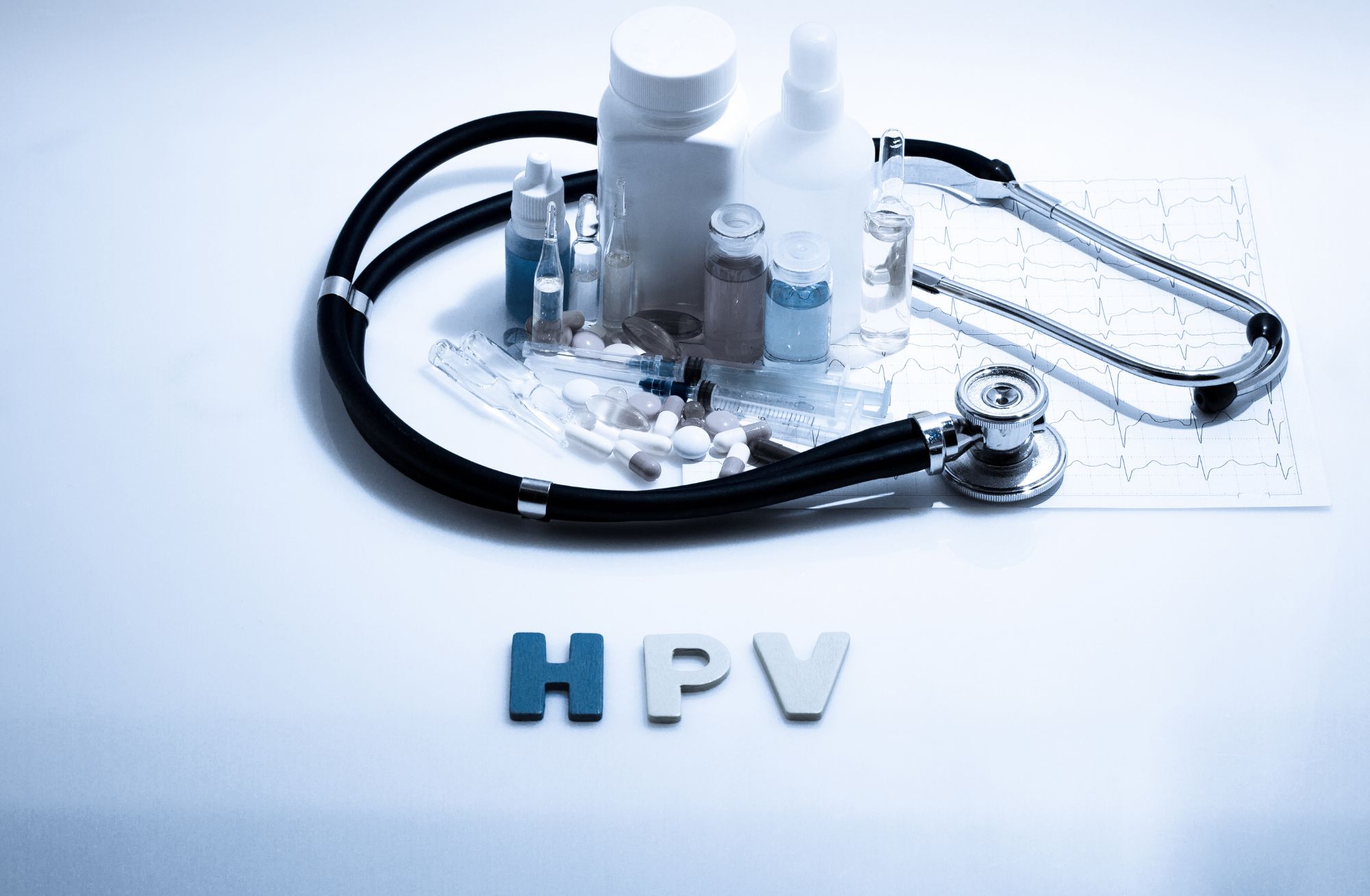 Diagnosis - HPV. Medical concept with pills, injection, stethoscope, cardiogram and a syringe.