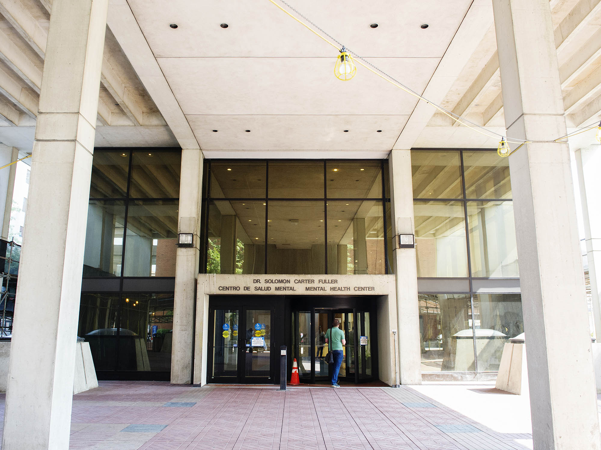 Photo: The front of a building, with two columns on the side. The front is all glass windows and there is an archway that reads the building's name.