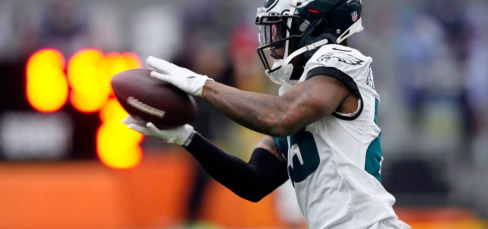 Photo: Philadelphia Eagles' C.J. Gardner-Johnson catches a pass during practice at the NFL football team's training facility, Friday, Feb. 3, 2023, in Philadelphia. A Black man wearing a dark green and white Eagles' football uniform and helmet catches a football in his hands.