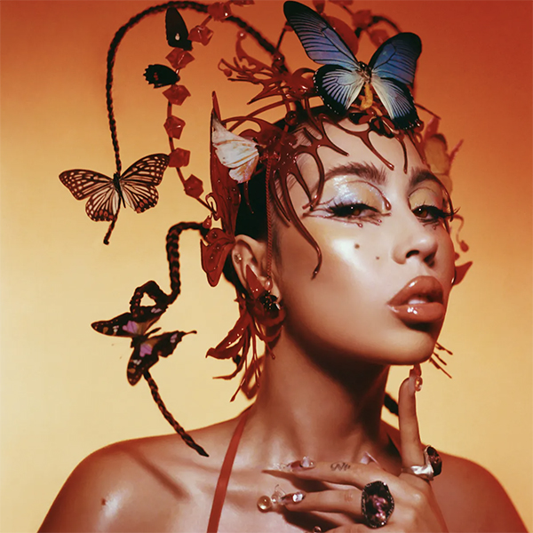 Album cover for Kali Uchis' Red Moon in Venus. Image shows Kali Uchis, a light-skinned Black woman wearing an elaborate butterfly headdress posing against a red-yellow background.