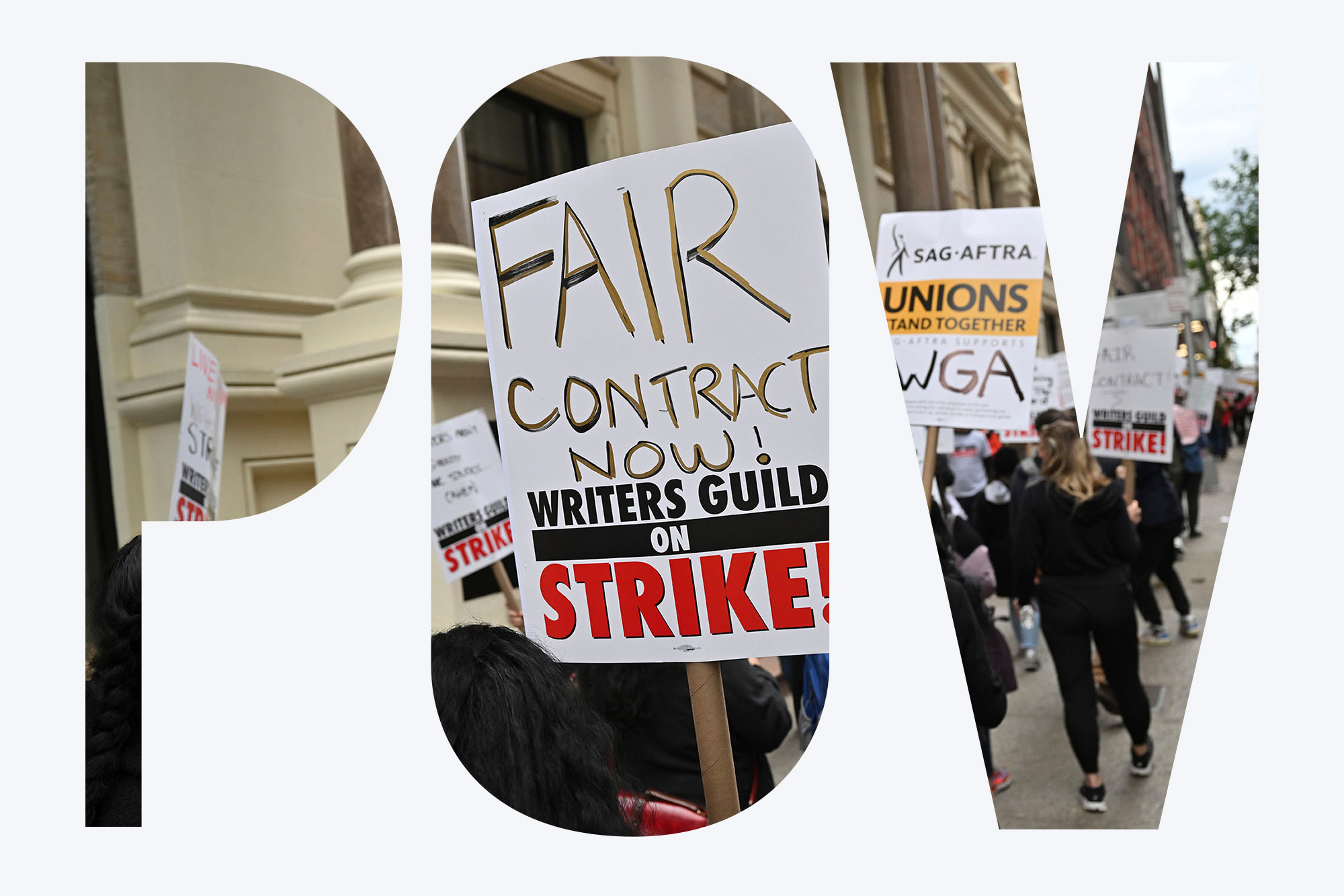 Photo: A group of strikers hold up signs protesting the unfair decisions and contracts made for writers in the writer guild. The prompt sign in the middle of the photo reads: "FAIR CONTRACT NOW! WRITERS GUILD ON STRIKE". The photo has a POV overlay on it.