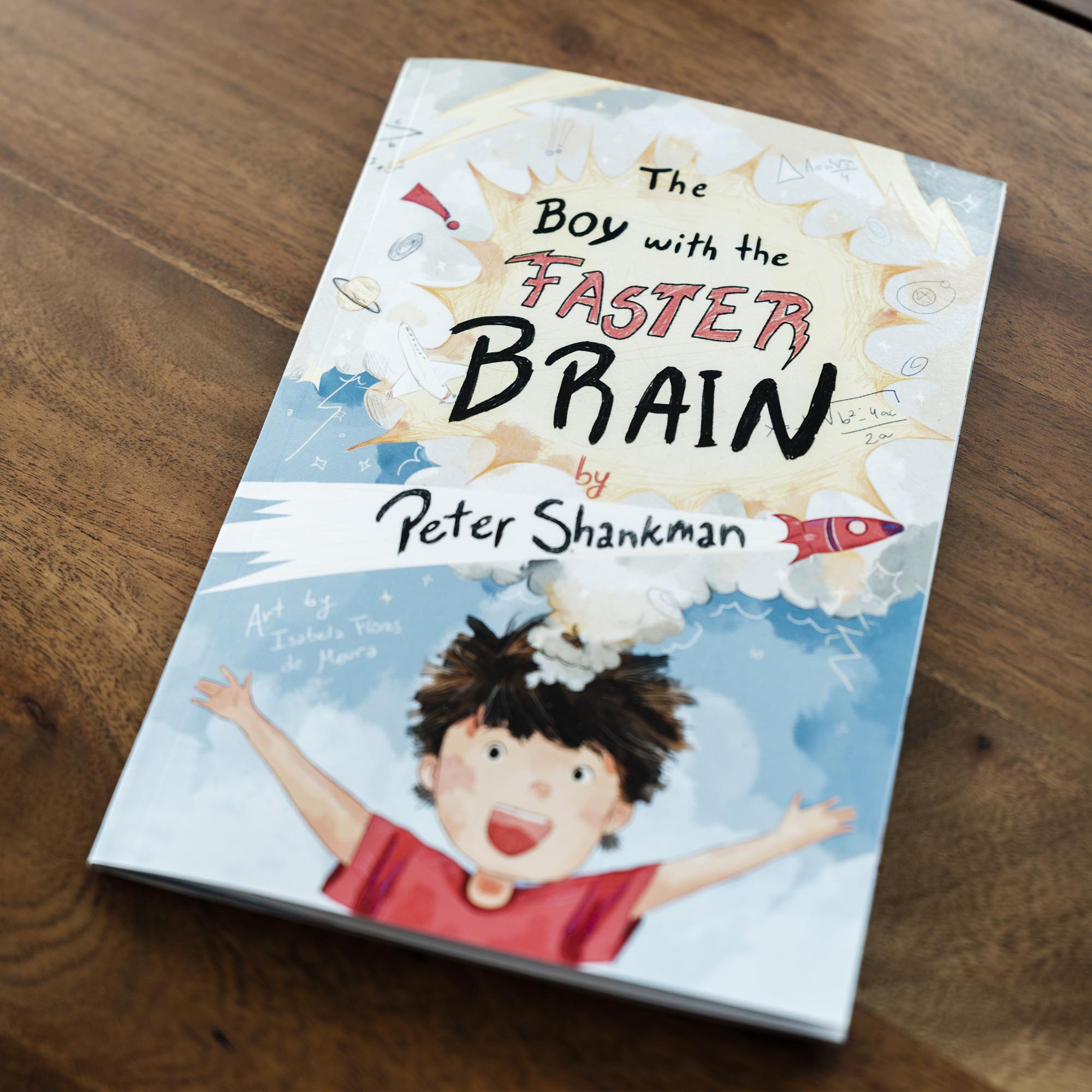 Photo: A book titled "The boy with the faster brain" laying on a wooden table.