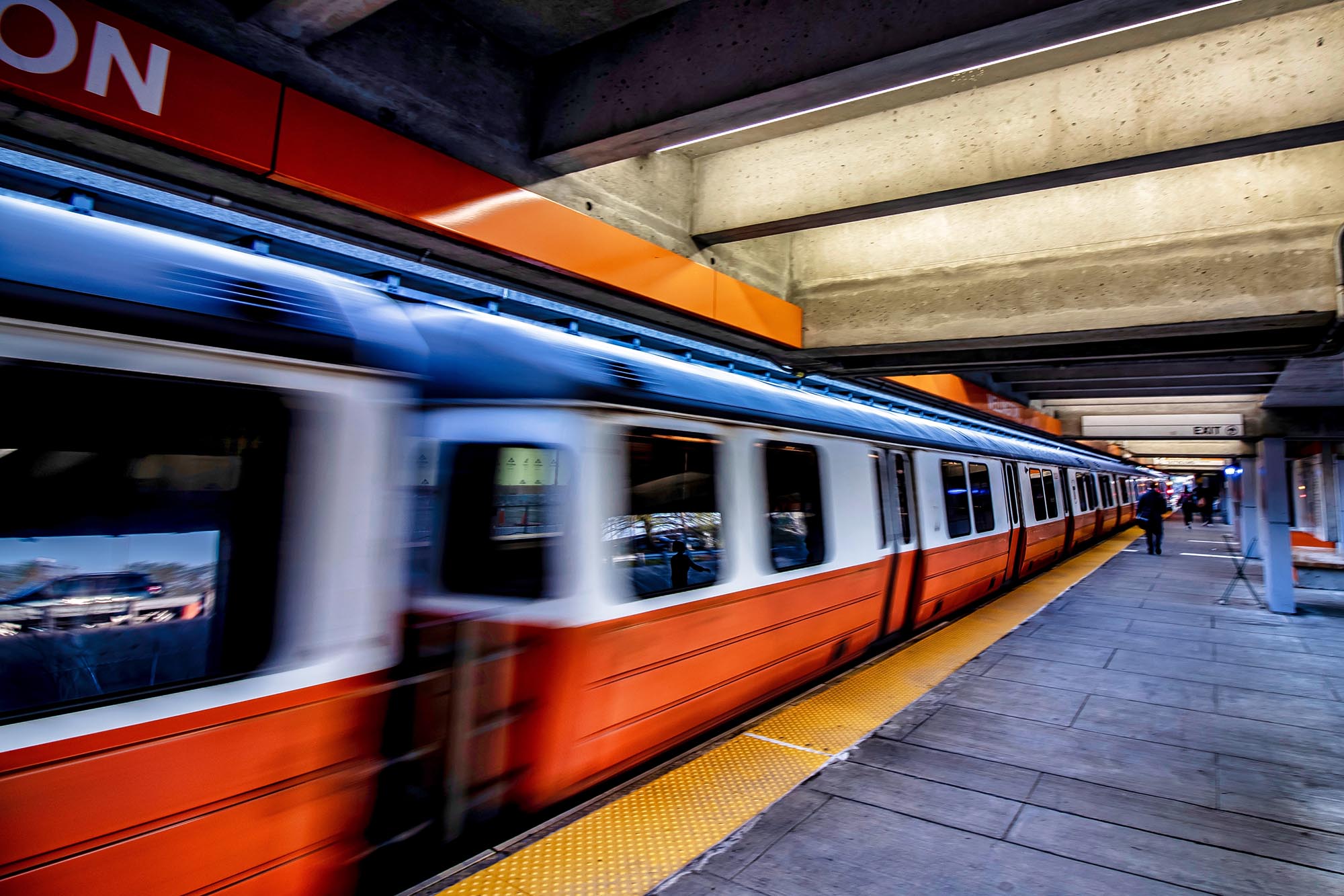 Photo: Wellington Train Station of the MBTA Orange Line at Everett, Massachusetts. An Orange train speeds by underground.