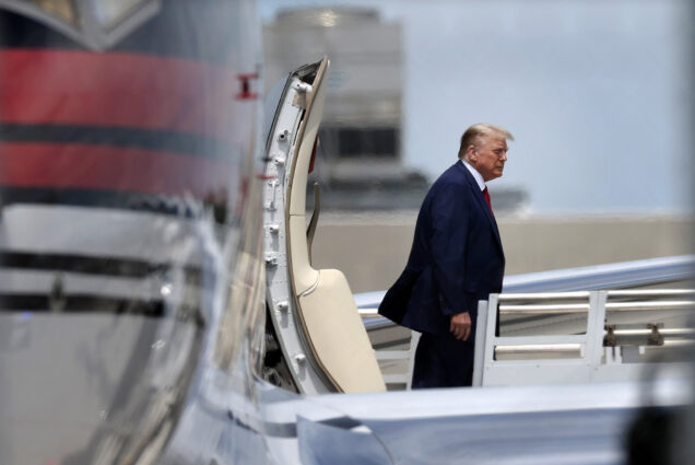 Photo: Donald Trump getting off a plane in a navy suit for his Miami trail.