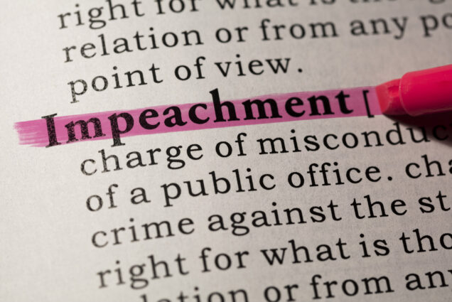 Photo: closeup photo of a dictionary page. Photo is zoomed onto the word "impeachment" which is shown being highlighter with a pink highlighter.