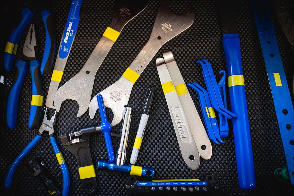 Photo: A variety of bike tools are shown strewn out on a black mat.