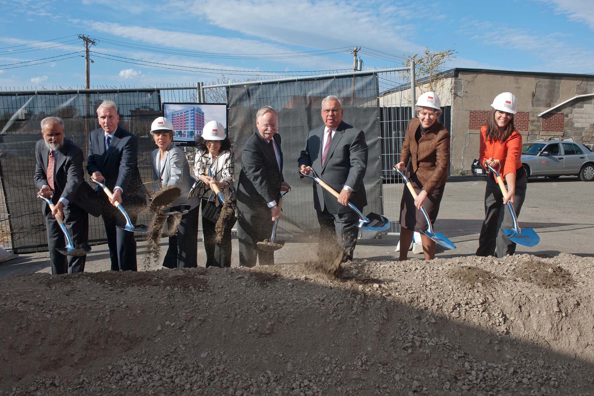 Photo of the groundbreaking for New Boston University School of Medicine. A group of people with shovels and hardhats stand in front of a pile of gray dirt; a green and gray chain link fence is seen behind them. The people seen, left to right, are: Ash Dahod Joe Fallon, Fallon Towle Associates Sherry Leventhal, BUSM Dean‚Äôs Advisory Board member Shamim Dahod, CAS'78 CGS'76 MED'87 BUSM Dean‚Äôs Advisory Board member and BU Overseer President Robert Brown Mayor Tom Menino Dean Karen Antman Catherine Spina, MED 2015 MD/Phd Candidate.