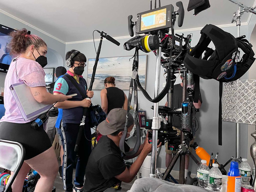 Photo: A large camera and camera crew are shown being set up on an indoor set.