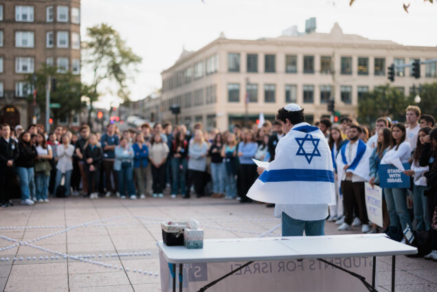 Photo: A college student draped in an Israeli flag gives a speech at a recent vigil for Israelis killed in the Israel Hamas war
