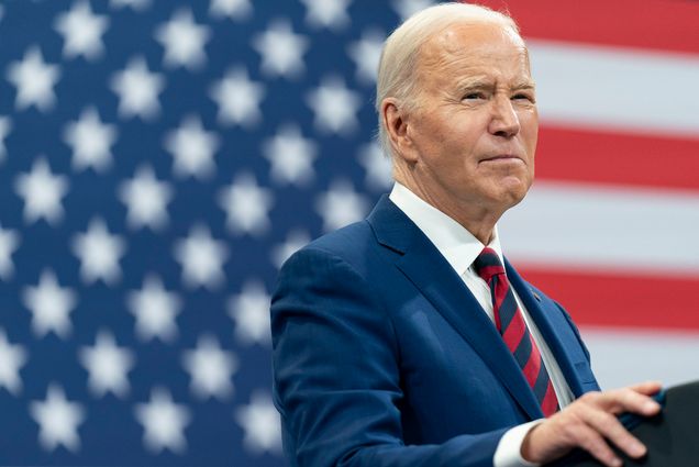 Photo: President Joe Biden delivers remarks during a campaign event with Vice President Kamala Harris in Raleigh, N.C. He stands in front of an American flag with a navy suit and red tie.