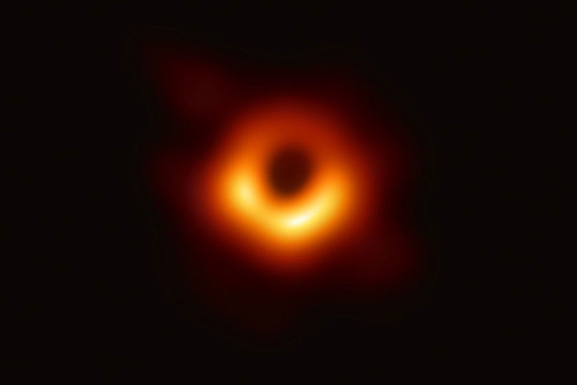 Photo: Early image of black hole. There is a ring of orange surrounded by darkness