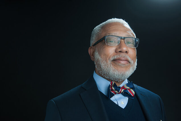 Photo: A portrait shot of Walter Fulker, a Black man with gray hair and beard wears a suit and bow tie.