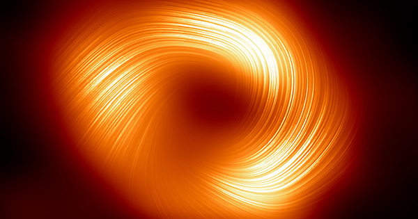 Photo: A new image of a supermassive black hole. There are orange swirls that are surrounded by darkness