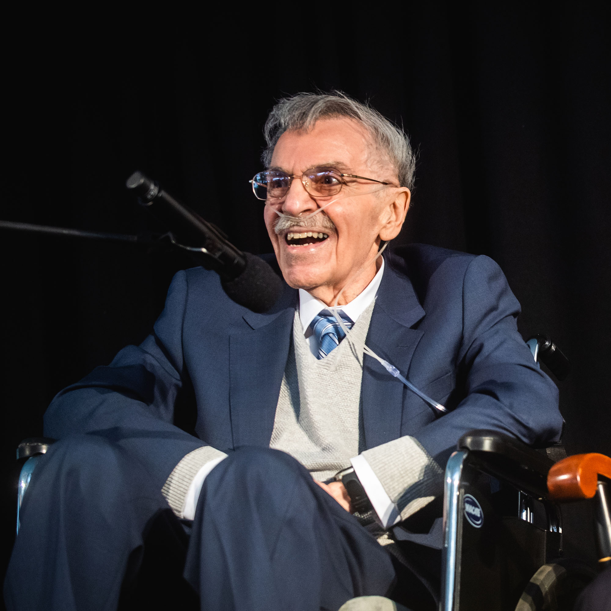 Photo: Edward Avedisian, an older man in an elegant suit, smiles at an event at Boston University in 2022