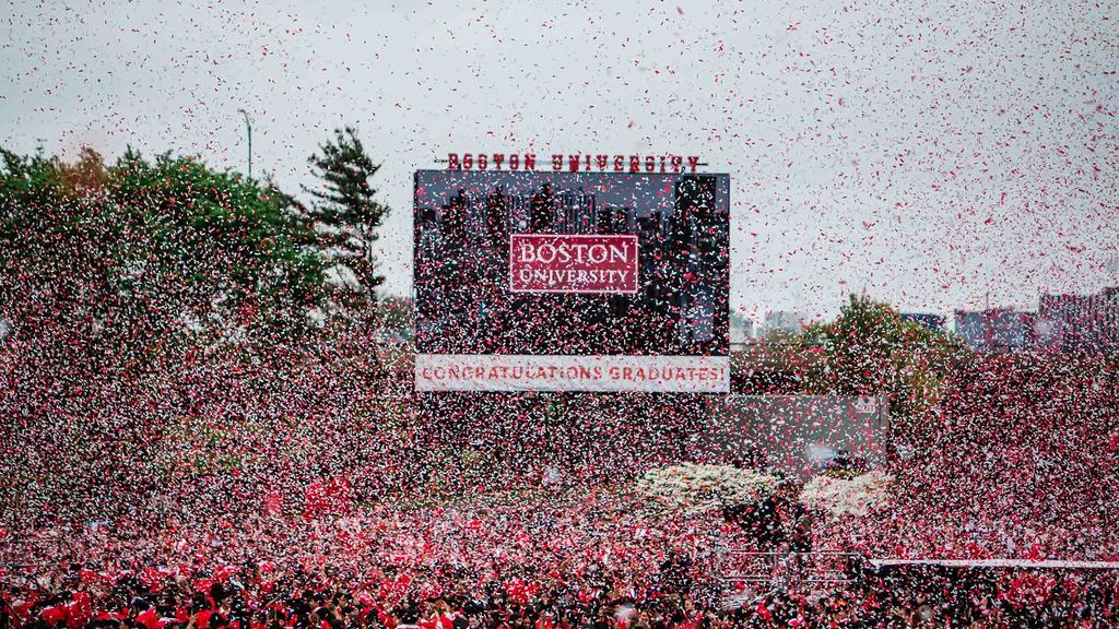 Photo: A sea of confetti over a large crowd of graduates in red gowns at the 2024 Boston University Commencement