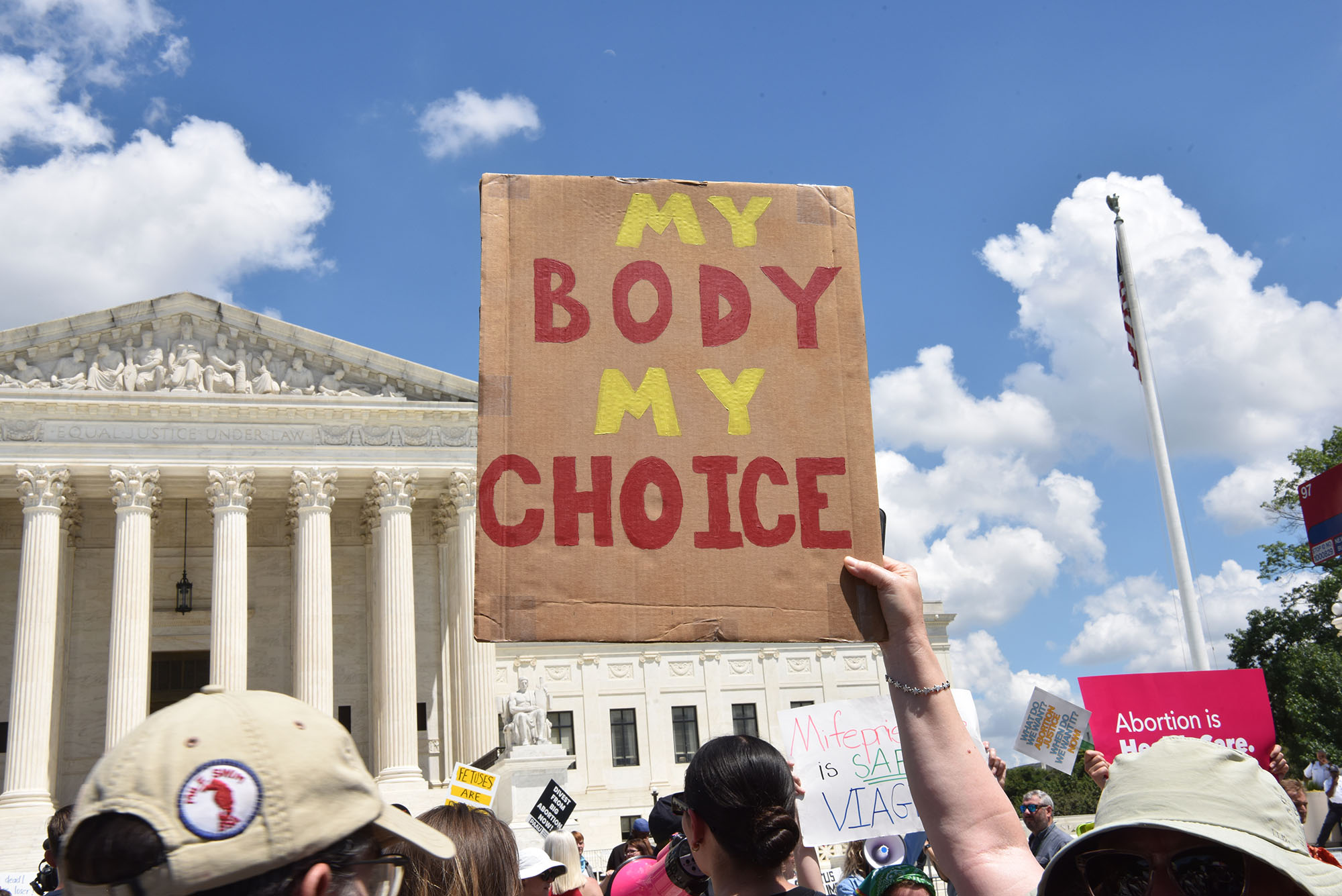 Photo: A picture of a person holding up a sign that says "My Body My Choice" outside of the United States Supreme Court Building